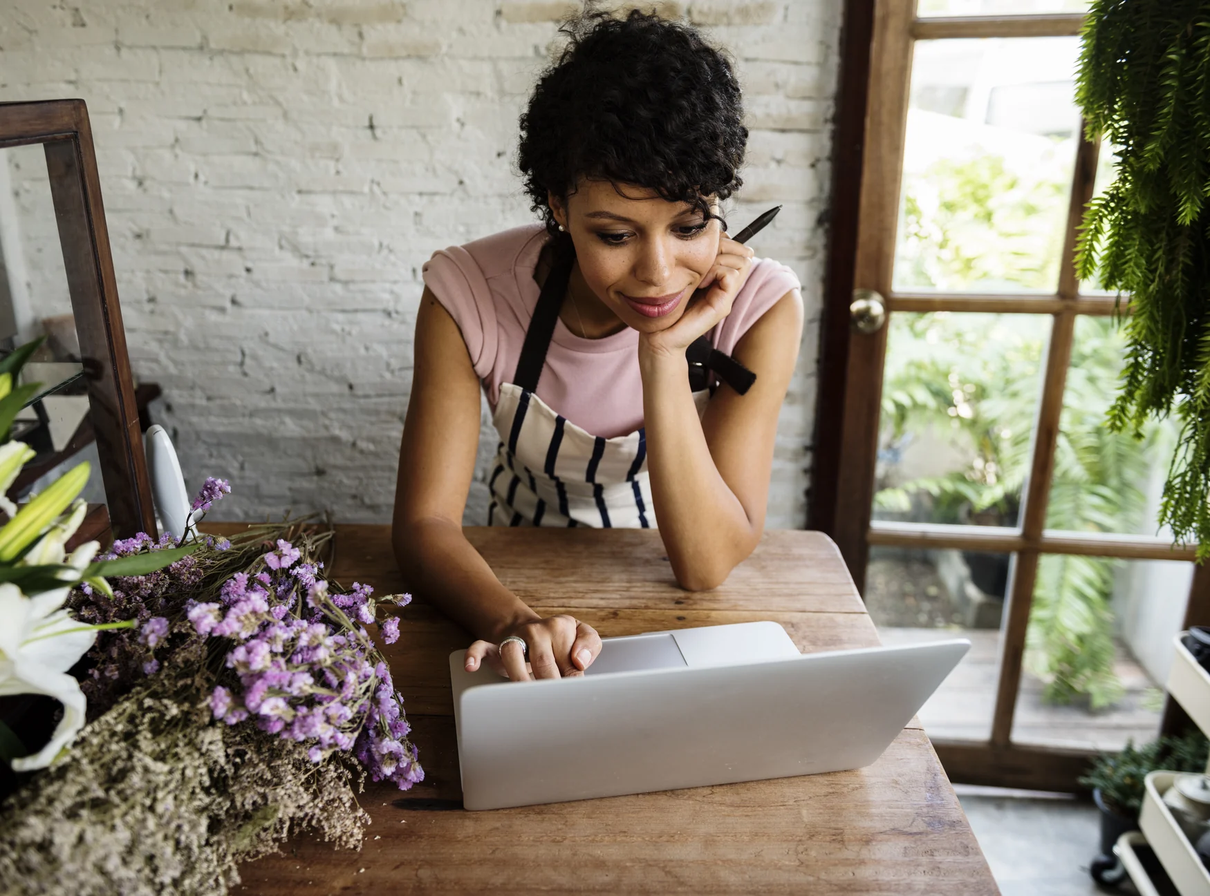 Mulher usando um notebook em uma floricultura