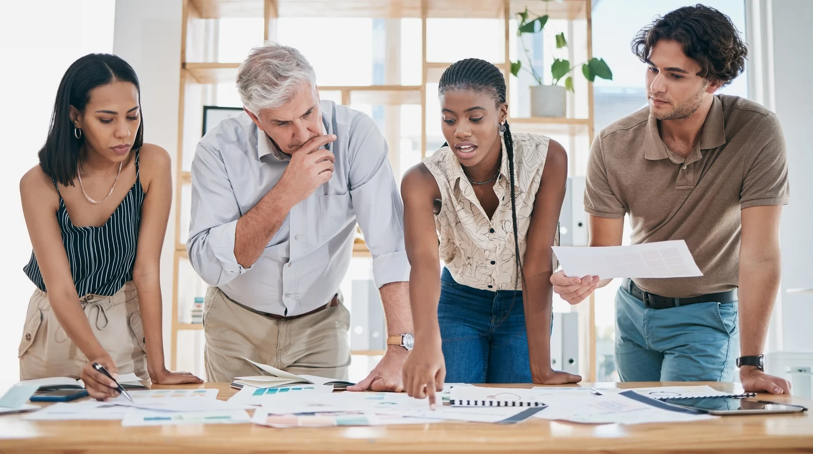 Equipe reunida para analisar documentos de trabalho